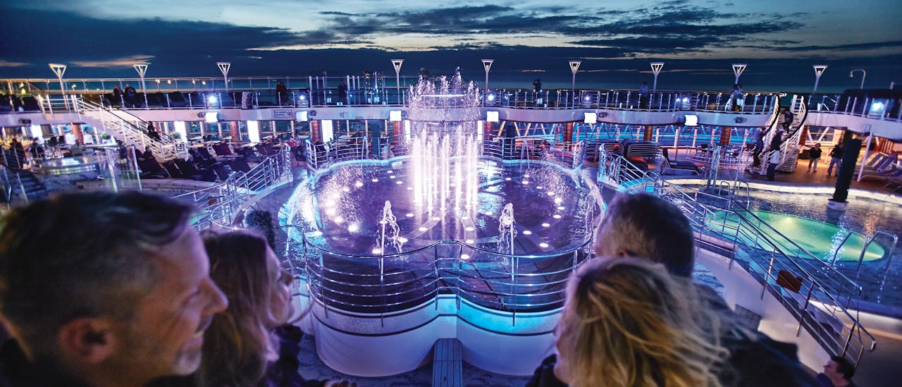 Et glitrende vandshow på pooldækket koreograferet med farver og musik